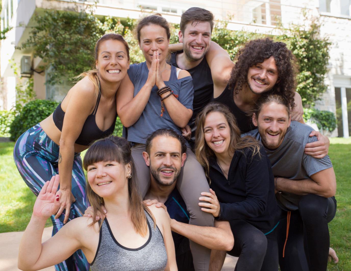 A group of staff members wearing yoga clothes smile at the camera